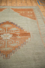 Distressed Kars carpet, stepped terracotta medallion, starburst florals, and mostly even wear.