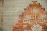 Textural detail of the distressed Kars rug with stepped terracotta and sage patterns.