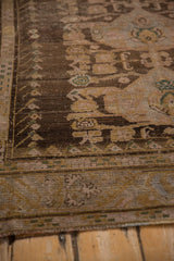 Distressed Anatolian carpet detail, showing worn chocolate brown, antique ivory, and dusty rose.