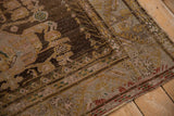 Distressed chocolate brown Anatolian rug showing worn pile, dusty rose and teal hues.