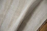 Close-up of the hand-woven plain-weave hemp kilim texture with soft ivory and beige abrashes.