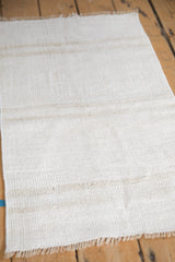 Textured plain-weave of a Turkish hemp kilim with soft shades of ivory and beige.