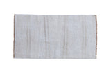 A plain-weave vintage hemp kilim rug with natural horizontal abrashes in ivory and platinum tones.