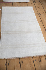 Angled perspective on a vintage hemp kilim, showing its textured weave and soft beige abrashes.