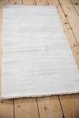Angled view of a vintage hemp kilim rug highlighting its textured plain weave and short fringe.