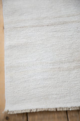 The natural plain-weave texture and secure machine-bound edge of a vintage hemp kilim.