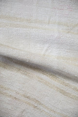 A soft fold revealing the nubby plain-weave texture of a vintage hemp kilim.