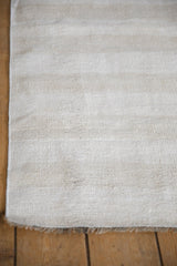 Close-up of the vintage hemp kilim's secured end, natural abrashes, and fringe.