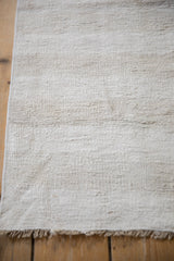 Plain-weave texture and secured fringe of vintage hemp kilim runner in soft natural shades.