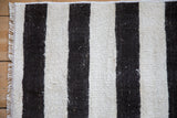 Charcoal and ivory striped plain-weave Turkish Hemp Kilim rug detail, showing fringe and bound edge.