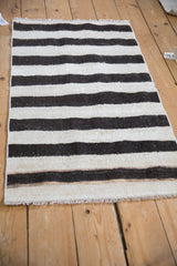 Detailed view of plain-weave vintage Turkish kilim with charcoal and ivory striped abrashes.