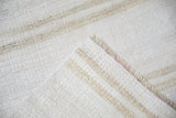Folded plain-weave vintage Turkish kilim runner, showing natural abrashes and secured fringed edge.