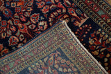 Intricate hand-knotted Sarouk foundation and floral pile with red, blue, and sand tones.