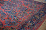 American Sarouk carpet's brick red field, blue floral sprays, and navy border.