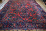 End of a vintage American Sarouk rug, showcasing navy floral border and brick red palmettes.