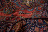 Textured pile of a vintage Sarouk rug, with floral sprays in brick red and blue.