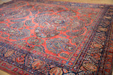 American Sarouk's brick red field with dense floral palmettes and navy blue border.