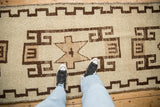 Textured pile of Vintage Kurd runner with brown geometric rectilinear patterns on ivory.