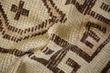 Close-up of a vintage Kurd rug's textured, shorn pile with chocolate brown geometric motifs.