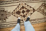 Geometric stylized patterns in ivory and brown tones on a vintage Kurd runner.
