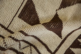 Textured shorn pile displaying geometric dark chocolate brown and ivory patterns.