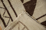 Vintage Kurd rug detail: shorn thin ivory and dark brown geometric pile, foundation, and side selvage.