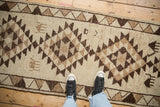 Looking down at the vintage Kurd runner's textured low pile and brown geometric design.
