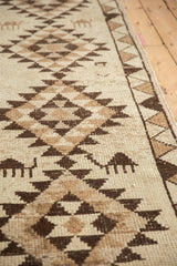 Hand-knotted pile of a Kurd runner with four-legged animal motifs and a serrated gul medallion.