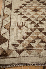 Detail of the four-legged animal motif and triangle border on a vintage Kurd rug.