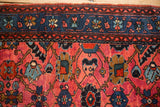 Sapphire blue main border with floral palmettes against the ruby red field of a vintage Lilihan rug.