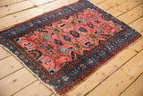 Angled view of the vintage Lilihan rug highlighting its hand-knotted texture and tattered ends.