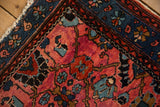 Worn edge and intricate sapphire blue border of a hand-knotted Persian Lilihan rug.