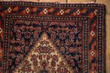 Stepped ivory corner spandrel and serrated leaf border on a hand-knotted vintage Senneh rug.