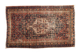 Antique Senneh rug, navy blue and brick red Herati motif, central diamond medallion, storied patina.