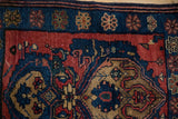 Close-up of the main border showing floral cross sections in sapphire blue and madder red.