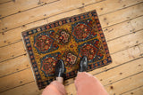 Antique Farahan Sarouk rug mat with gold field and stylized medallions, shown for scale.