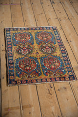 Perspective view of a square Farahan Sarouk rug with its four stylized tree-of-life medallions.