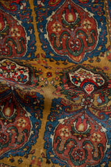 Detailed view of a fine Farahan Sarouk's wool pile showing scrolling medallions in red, blue, and gold.