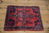 Angled overhead view of a gem-toned antique Sarouk sampler rug.
