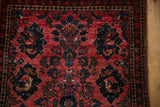 Detail of the vintage Persian Sarouk rug's central floral spray and meandering vine border.
