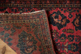 Folded corner of a vintage Sarouk rug displaying the hand-knotted back, foundation, and rich pile.