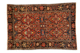 Antique Farahan Sarouk rug with an allover floral and palmette design on a madder red field and dark navy border.