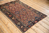 Angled view of a fine Farahan Sarouk rug's all-over floral pattern and dark navy border.