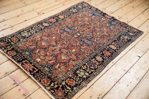 Full antique Farahan Sarouk rug shown at an angle, detailing its allover pattern and colors.