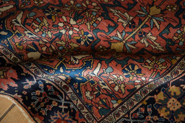Close-up of a fine antique Farahan Sarouk rug's texture and floral palmette design in red and navy.