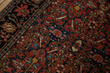 Late 19th-century Farahan Sarouk's navy palmette border adjacent to the madder red floral field.
