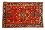 Vintage Sarouk rug with a quatrefoil medallion on a cherry red field and a navy blue floral border.