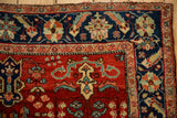 Close-up of the vintage Sarouk's navy border showing ornate palmette and leaf details.