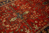 Vintage Sarouk rug's textured red pile with a blue quatrefoil medallion and sprawling floral details.