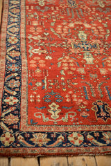Intricate palmette and serrated leaf designs in the navy border of a vintage Sarouk rug.